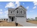Two-story home with gray siding, a two-car garage, and a mailbox in the front yard at 5144 Rolling Meadow Blvd, Indianapolis, IN 46237