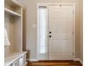 Front entry with white door, built-in shelving, and wood floors at 6265 Canterbury Dr, Zionsville, IN 46077