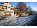 Two-story tan townhome with attached garage and snowy front yard at 7042 Tyler Ln, Indianapolis, IN 46217