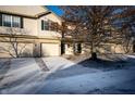 Tan townhome with attached garage; winter scene with snow on ground at 7042 Tyler Ln, Indianapolis, IN 46217