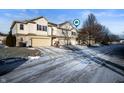 Two-story townhome with attached garage and snowy driveway at 7042 Tyler Ln, Indianapolis, IN 46217
