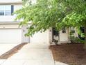 Attractive townhouse featuring an attached garage, well-maintained landscaping, and a welcoming entrance at 7042 Tyler Ln, Indianapolis, IN 46217