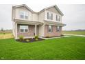Beautiful two-story home with brick and siding, complemented by a green lawn and landscaping at 7824 Magnolia St, New Palestine, IN 46163