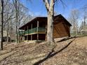 Cabin featuring a wraparound porch with green trim nestled among mature trees at 7887 Elk Dr, Nineveh, IN 46164