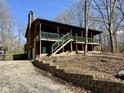 Beautiful cabin home with green trim, a wraparound porch, a two-car garage and landscaping at 7887 Elk Dr, Nineveh, IN 46164
