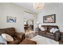 Cozy living room with brown leather furniture and a view into the dining area at 9847 Gallop Ln, Fishers, IN 46040