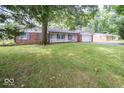 Ranch house with a large front yard and mature trees at 9876 Woodbriar Ln, Carmel, IN 46280