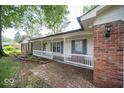 Brick home with a covered porch and brick walkway at 9876 Woodbriar Ln, Carmel, IN 46280