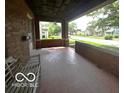 View of a covered porch featuring a bench and an open view of the neighborhood street at 1023 Franklin St, Columbus, IN 47201
