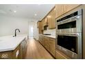 Modern kitchen with double ovens, an island, and light wood cabinets at 12507 Pasco St, Fishers, IN 46038