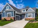 Home boasts blue siding, brick accents, an attached garage and a pristine lawn at 20188 Hampton Park Dr, Westfield, IN 46074