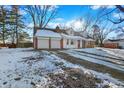 Ranch home with a two-car garage and a gravel driveway, covered in snow at 2934 S Irwin St, Indianapolis, IN 46203