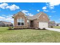 Charming brick home with manicured lawn and a two-car garage, situated in a peaceful residential neighborhood at 3844 Albert Ln, Bargersville, IN 46106