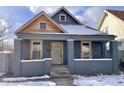 Gray house with wood accents and a snowy front yard at 416 N Grant Ave, Indianapolis, IN 46201