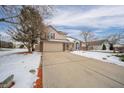 Two-story house with brick and beige exterior, attached garage, and snow-covered front yard at 6573 Crossbridge Dr, Noblesville, IN 46062