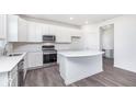White kitchen with stainless steel appliances and an island with white countertops at 7184 Firestone Rd, Whitestown, IN 46052