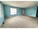 Spacious living room with neutral carpet and bright blue walls at 7903 Roseway Ct, Indianapolis, IN 46226