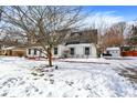 White brick ranch home with gray roof, snowy yard, and driveway at 820 Dayton Dr, Carmel, IN 46033