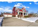 Red two-story house with a long driveway and snowy landscaping at 8758 Carver Dr, Indianapolis, IN 46239