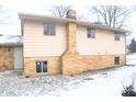 Side view of a ranch home with brick and siding exterior, showcasing a chimney at 9157 Neptune Dr, Indianapolis, IN 46229