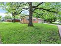 A cozy home with a lush lawn and mature trees, nestled in a serene neighborhood setting at 9157 Neptune Dr, Indianapolis, IN 46229
