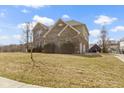 Side view of a brick home showcasing the well-kept lawn and attached garage at 11383 Sea Side Ct, Fishers, IN 46040