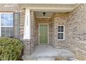 Close-up of the home's entry, featuring a green front door and brick facade at 11383 Sea Side Ct, Fishers, IN 46040