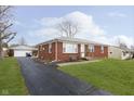Brick ranch home with a paved driveway and attached garage at 1215 N Shortridge Rd, Indianapolis, IN 46219