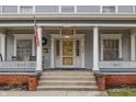 Inviting front porch with columns and a yellow front door, perfect for enjoying the outdoors at 1319 N New Jersey St, Indianapolis, IN 46202