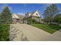 Well-maintained brick home showcasing a spacious driveway, lush lawn, and mature landscaping at 16395 La Paloma Ct, Noblesville, IN 46060