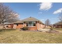 Backyard view of this red brick townhome with a well maintained lawn and patio at 306 Vinewood N Dr, Brownsburg, IN 46112