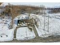 Aerial view of a ranch house on a snowy lot with a detached garage at 4305 Five Points Rd, Indianapolis, IN 46239