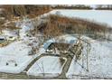 Aerial view of a house and detached garage on a snowy lot near a road at 4305 Five Points Rd, Indianapolis, IN 46239