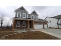 View of new home, showcasing brick and gray siding, a covered front porch and two-car garage at 5511 Sienna Ct, Brownsburg, IN 46112