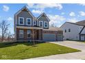 Attractive home with a brick and gray facade, complemented by a lush green lawn and a convenient three-car garage at 5511 Sienna Ct, Brownsburg, IN 46112