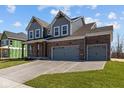 Lovely two-story home boasting a brick and gray exterior, showcasing a well-kept lawn and a spacious three-car garage at 5511 Sienna Ct, Brownsburg, IN 46112
