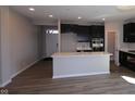 Open kitchen with a large island, modern appliances, and black cabinets at 5511 Sienna Ct, Brownsburg, IN 46112