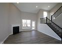 Bright living room features a fireplace, large windows, and staircase with iron railings at 5511 Sienna Ct, Brownsburg, IN 46112