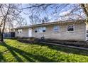 Well-kept stone-faced single-story home with healthy green grass and a pleasant, welcoming appearance at 8415 E 10Th St, Indianapolis, IN 46219