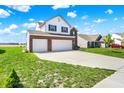 Spacious home with a wide driveway, three-car garage, and verdant lawn at 977 Capricorn Dr, Franklin, IN 46131