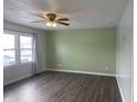 Living room with gray and green walls, wood-look floors, and a ceiling fan at 1360 S Cherry St, Martinsville, IN 46151