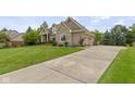 Spacious home featuring a well-manicured lawn, long driveway, and attached two-car garage at 14832 Sulky Way, Carmel, IN 46032