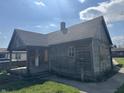 Rustic wood house needing some TLC, with a covered porch at 1520 N Bancroft St, Indianapolis, IN 46201