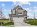 Charming two-story home with gray siding, white trim, two-car garage, and landscaped yard at 2310 Marjorie Way, Shelbyville, IN 46176