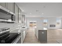 Modern kitchen featuring stainless appliances, light grey cabinets, quartz countertops and LVP flooring at 2310 Marjorie Way, Shelbyville, IN 46176