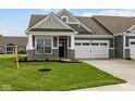 Charming home featuring a two-car garage, stone accents, and well-manicured lawn at 3617 Wrangler Dr, Bargersville, IN 46106