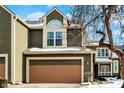 Two-story green house with a tan garage door and snowy yard at 4669 Stansbury Ln, Indianapolis, IN 46254