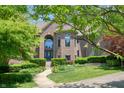 Brick home with an arched entry, green landscaping, and a winding sidewalk to the front door at 6012 Yellow Birch Ct, Avon, IN 46123