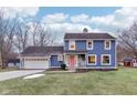 Blue house with a pink door, white trim, and attached garage at 635 Terrace Dr, Zionsville, IN 46077