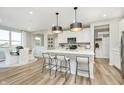 Modern kitchen with white cabinets, island, stainless steel appliances, and hardwood floors at 6783 Karleigh Dr, Brownsburg, IN 46112